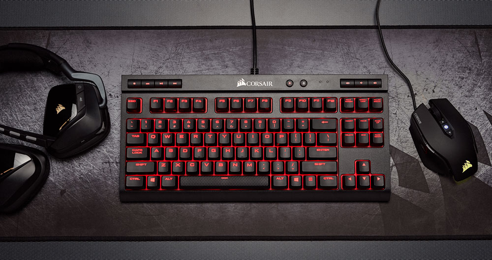Corsair black keyboard with red light backing and headset/mouse.